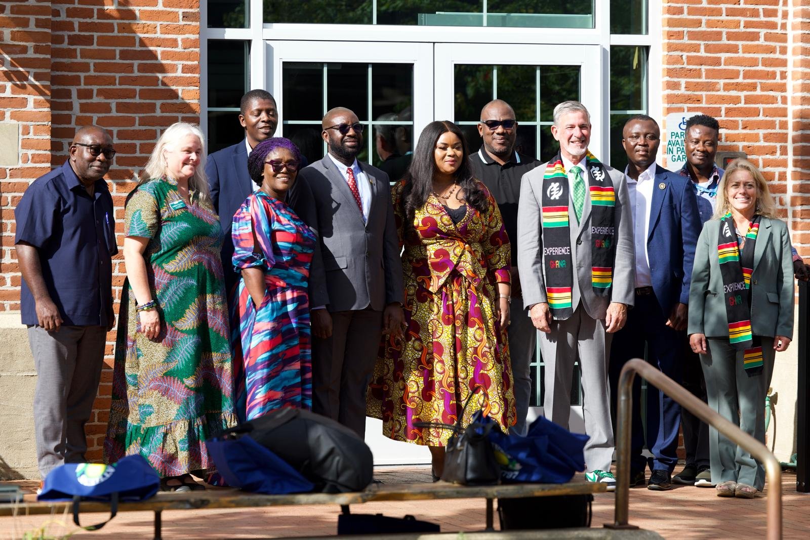 Delegation members gathered outside a campus building wearing Experience Ghana scarves